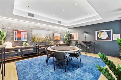 a conference room with a round table and chairs and a blue rug